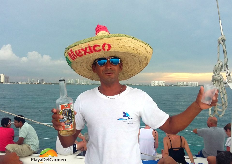 Guy with a sombrero and a drink in his hands on a boat