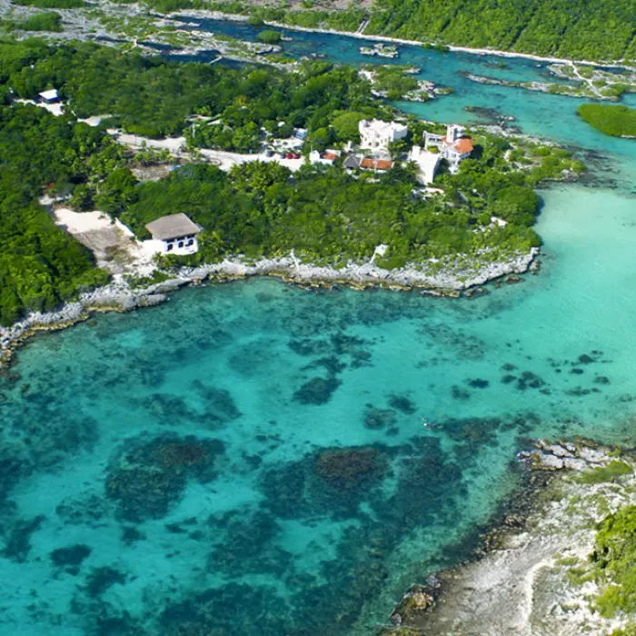 Aerial view of crystal-clear Caribbean waters and lush jungle, showcasing the beautiful snorkeling locations