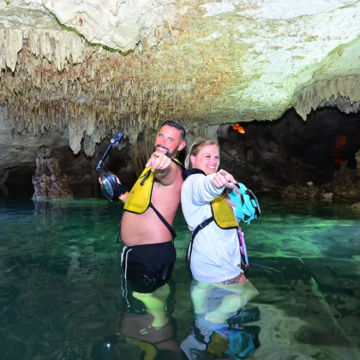 Couple enjoying a guided snorkeling tour inside a cenote in Riviera Maya, part of the Mayan Adventure Tour