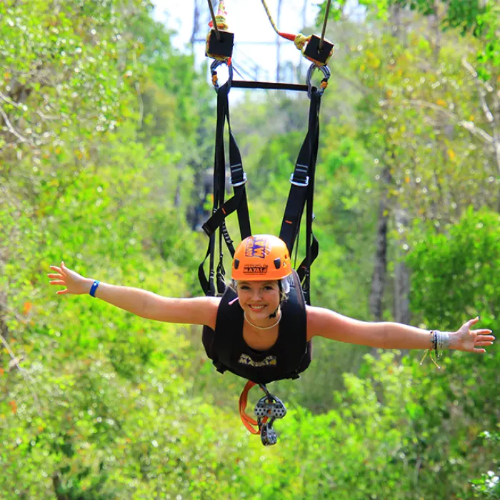 Woman enjoying the superman zipline ride through the jungle in Tulum