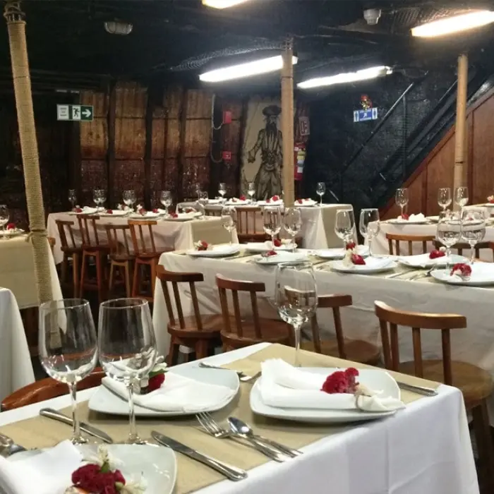 Captain Hook Cancun dinner show, showing a table with plates and wine glasses
