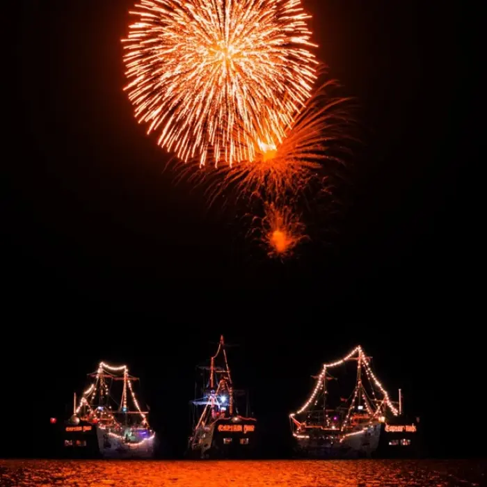 Captain Hook Cancun fireworks, showing a large firework display over the illuminated pirate ships at night