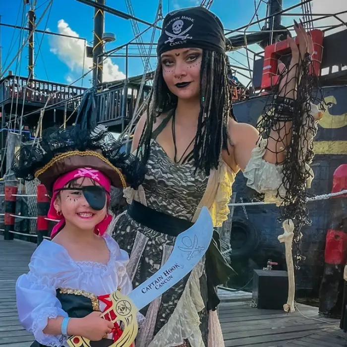 Captain Hook Cancun, a pirate with a young girl dressed as a pirate, on the deck of a pirate ship