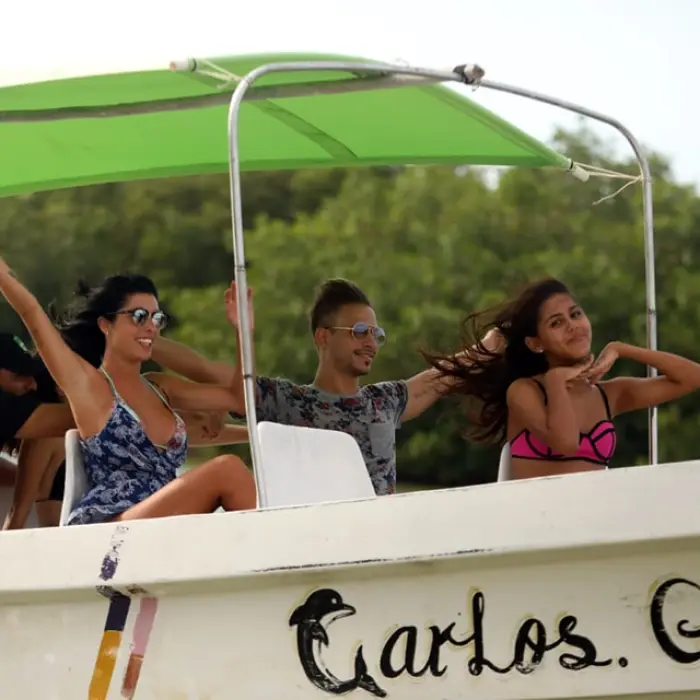Happy guests enjoying the sunny boat ride through the mangroves of Rio Lagartos, keeping an eye out for crocodiles and exotic birds.