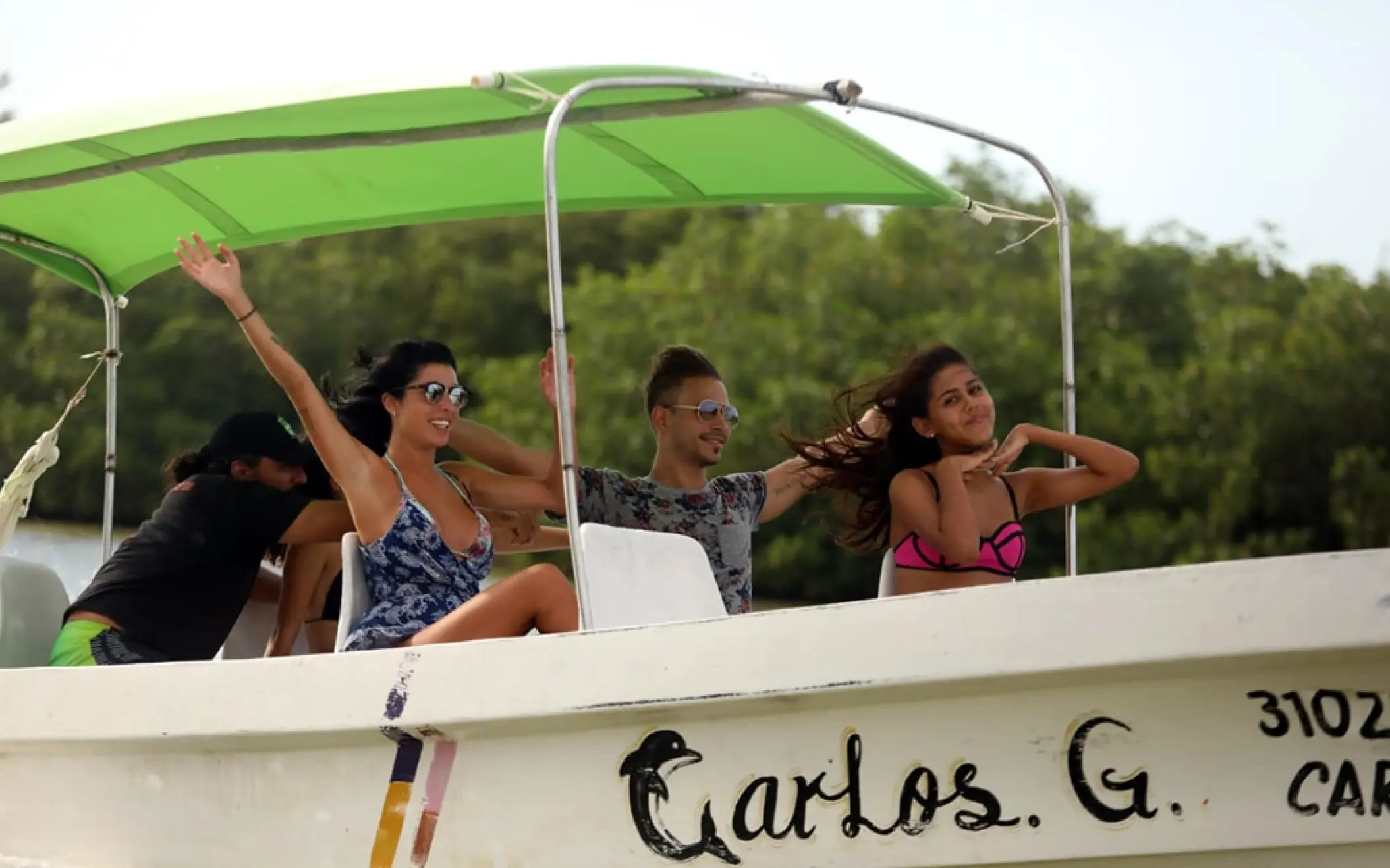 Happy guests enjoying the sunny boat ride through the mangroves of Rio Lagartos, keeping an eye out for crocodiles and exotic birds.