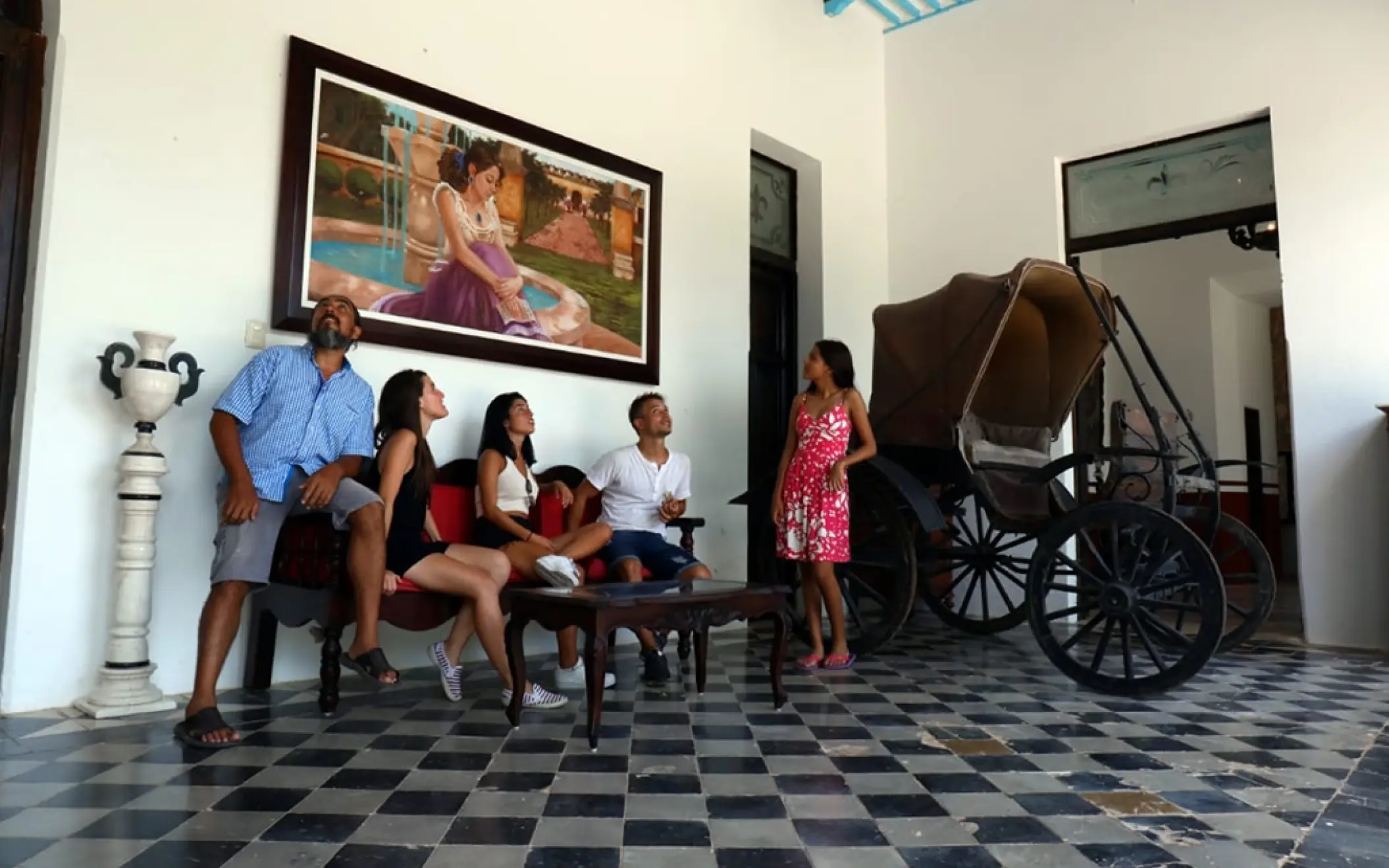 Our tour group relaxes inside a historic Yucatan hacienda, admiring the classic architecture and art before continuing their adventure.