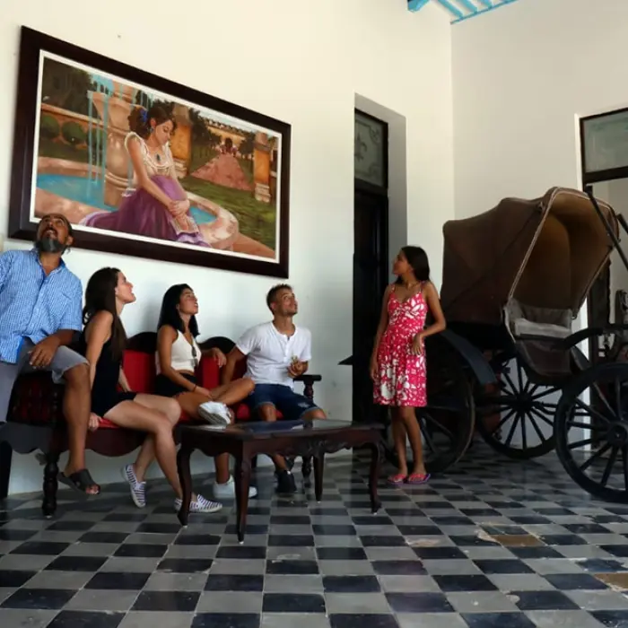 Our tour group relaxes inside a historic Yucatan hacienda, admiring the classic architecture and art before continuing their adventure.