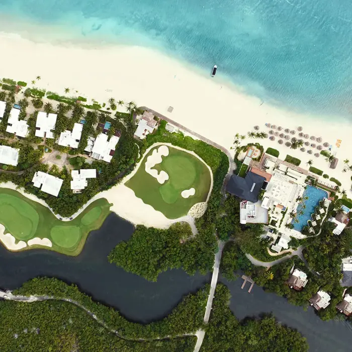 An aerial view of luxury beachfront villas and pristine oceanfront golf greens along the Mayakoba coast near Playa del Carmen.