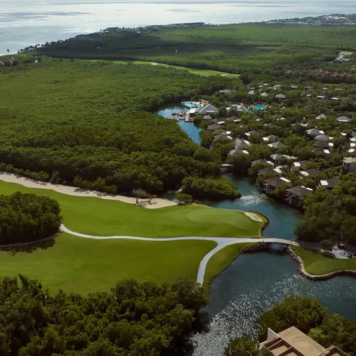 A high-angle view of the signature layout at Mayakoba showing freshwater lagoons winding through the tropical jungle fairways.
