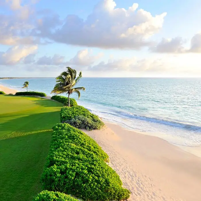 A beautiful oceanfront green running right alongside the white sand beach and turquoise Caribbean Sea at Mayakoba resort.