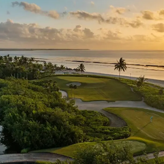 A breathtaking sunset view over the mangrove fairways and coastline at El Camaleón golf course in Riviera Maya.