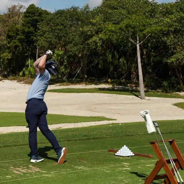 A golfer practices his swing at the premium driving range before his round at Gran Coyote Golf Club.
