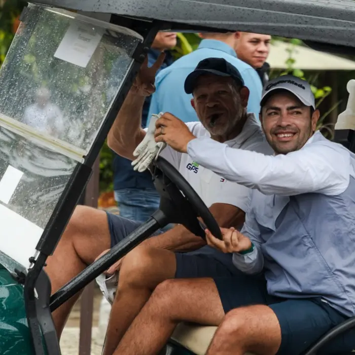 Two happy golfers enjoy their time riding in a premium golf cart at Gran Coyote Golf Club.