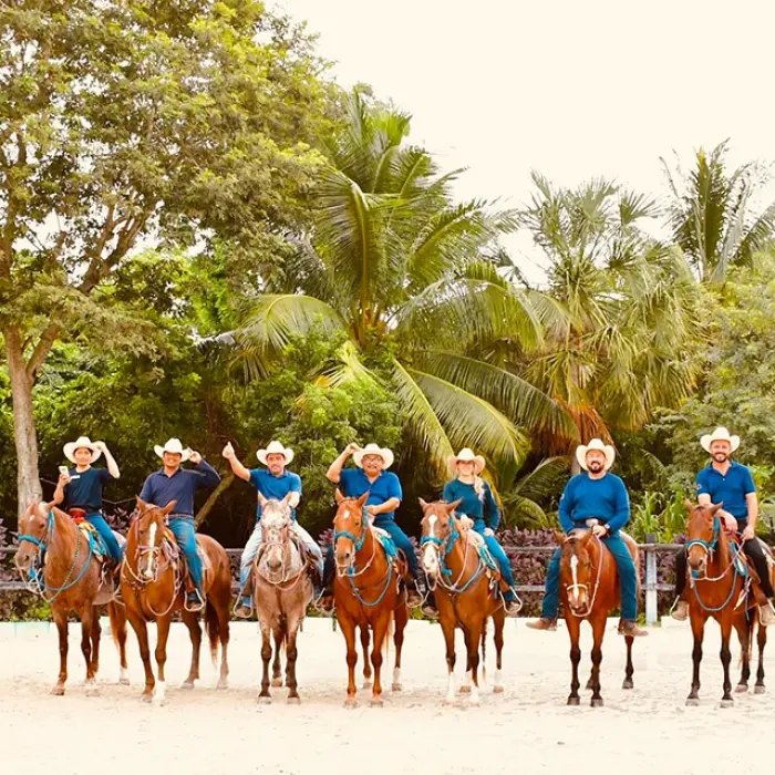 Line of people on horseback riding through a tropical area in Playa del Carmen. Group excursion