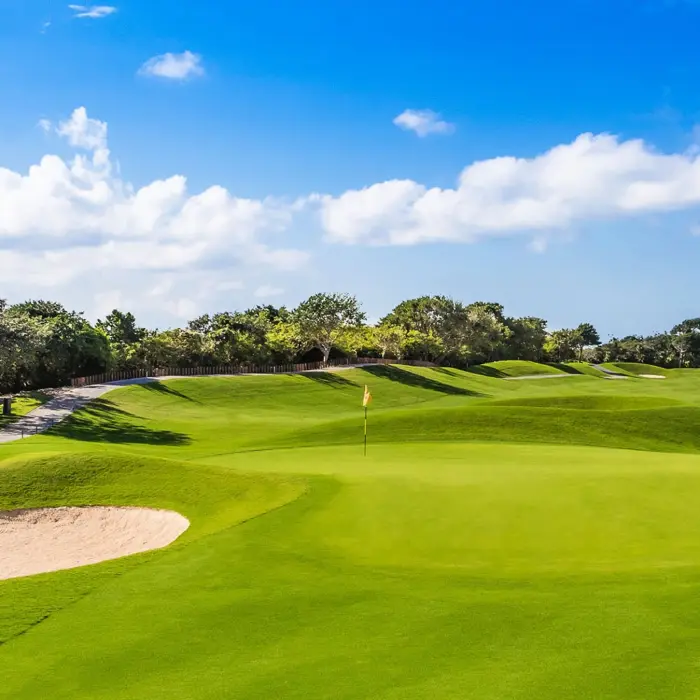 A bright and sunny view of a smooth, undulating fairway surrounded by dense Riviera Maya jungle at Iberostar Golf Club.