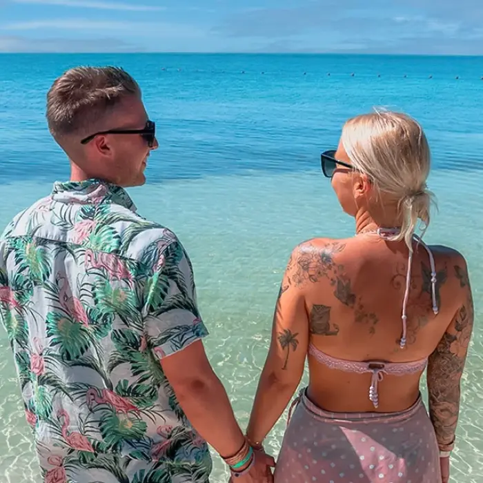 Couple walking by the turquoise waters of Isla Mujeres during the Paradise Islands: Isla Contoy & Isla Mujeres tour