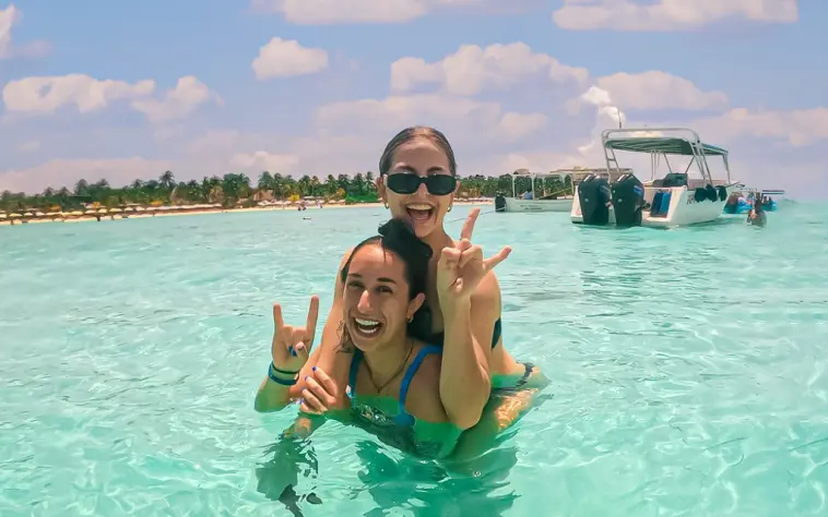 Two friends enjoying the shallow waters of Isla Mujeres on the Paradise Islands tour
