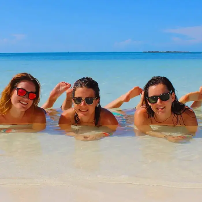 Group of friends floating in the shallow blue waters of Isla Mujeres on the Paradise Islands tour