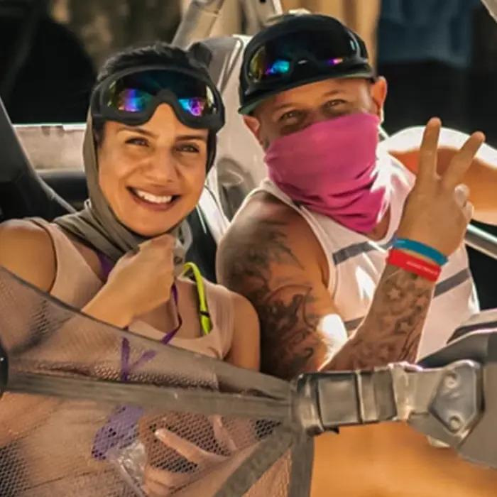 Couple in a buggy navigating through a muddy trail, enjoying an adventurous off-road ride