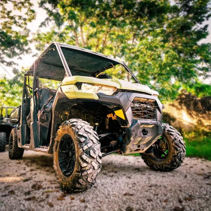 A buggy speeding through a dusty jungle trail, creating a cloud of dust during an exciting tour in The Riviera Maya