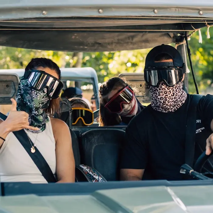 Family  in a buggy during a fun-filled jungle tour in Mexico, giving thumbs up for the camera