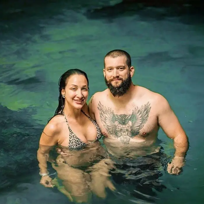 A couple enjoying the crystal-clear waters of a jungle cenote in Mexico, perfect for nature lovers