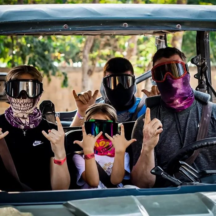 A family in a buggy during a fun-filled jungle tour in Mexico, giving thumbs up for the camera