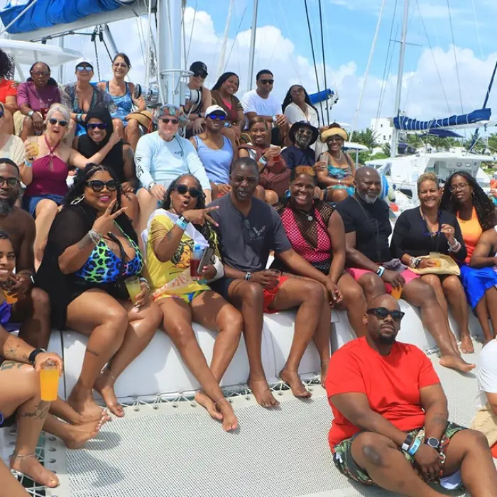 Happy group enjoying a luxury catamaran party with open bar and music