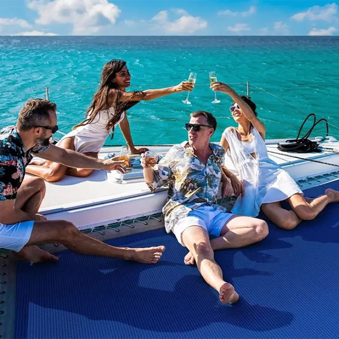 Friends toasting drinks on the deck of a luxury sailing catamaran