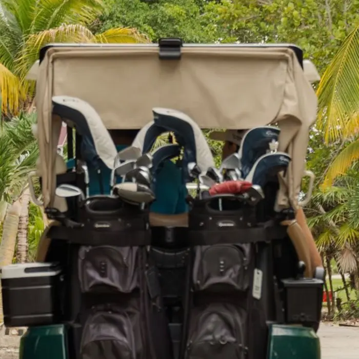 A modern GPS-equipped golf cart parked on a path overlooking the lush tropical fairways at Playa Mujeres Golf Club