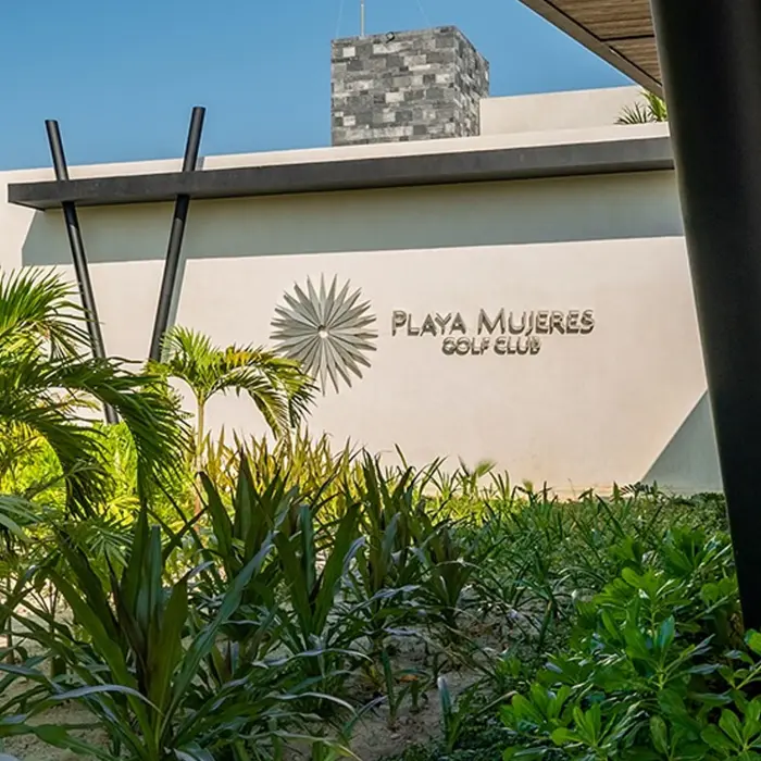 A beautiful panoramic view of the luxurious open-air clubhouse at Playa Mujeres Golf Club, overlooking the perfectly manicured practice greens