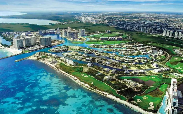 Aerial view of Puerto Cancún Golf Club showcasing the championship course, luxury marina district, and the beautiful Caribbean Sea.
