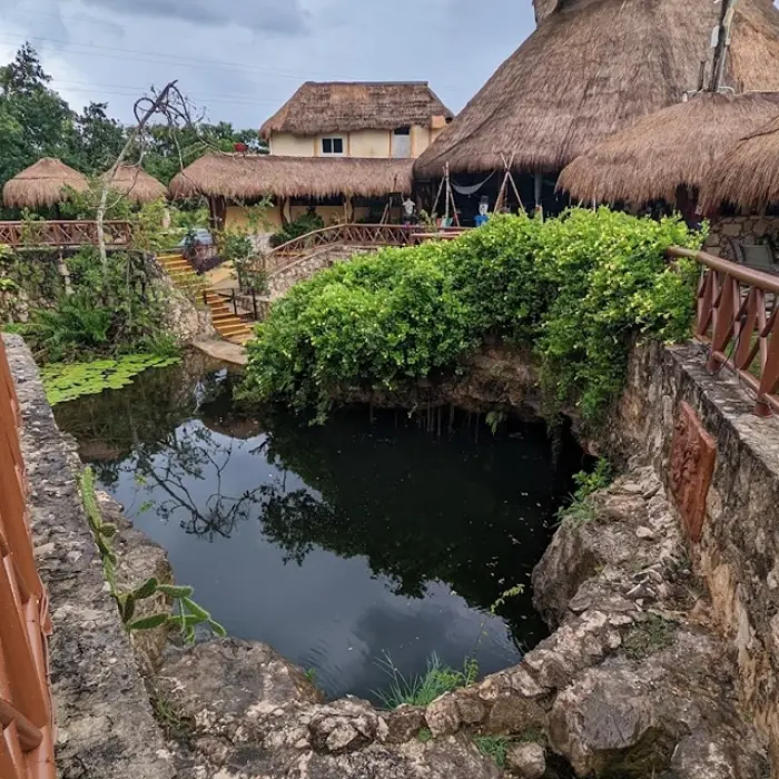 Cenote Azul Playa del Carmen: View of Cenote Azul from above, surrounded by lush vegetation and palapa-roofed structures