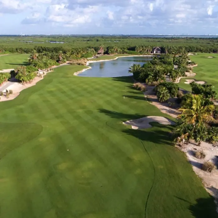 An expansive aerial perspective showcasing the championship fairways winding through vast, protected mangroves and tropical jungle