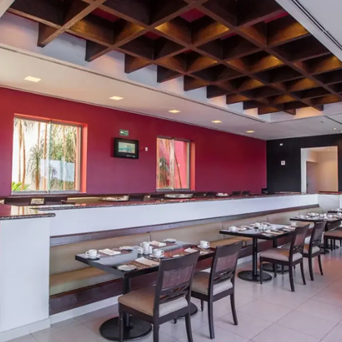 The elegant interior of the Riviera Cancún luxury clubhouse restaurant, featuring rich wood details and tables set for premium dining