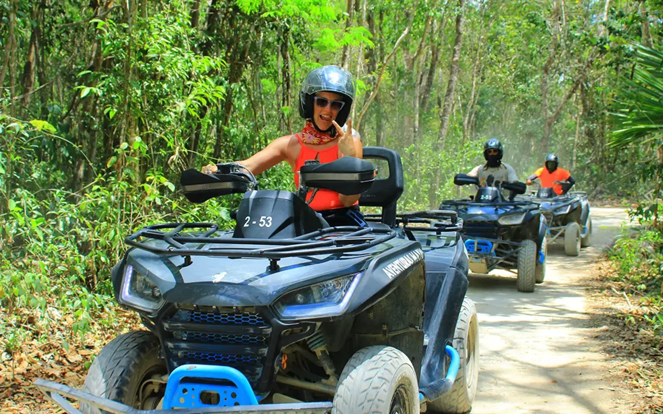 Tourist riding an ATV on a jungle trail, surrounded by lush tropical vegetation