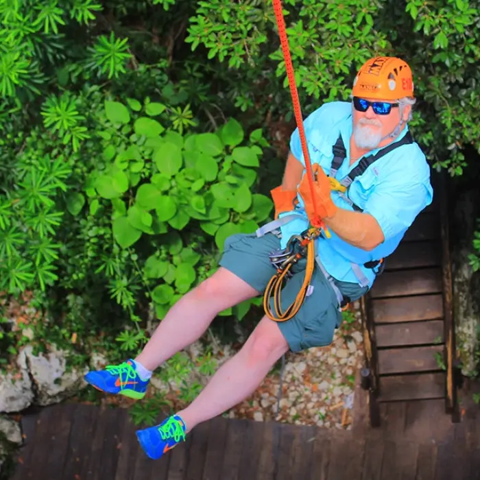man ziplining over a jungle canopy, smiling during an adventure activity