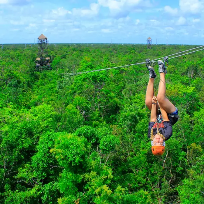 Upside down ziplining over a lush jungle canopy in Mexico