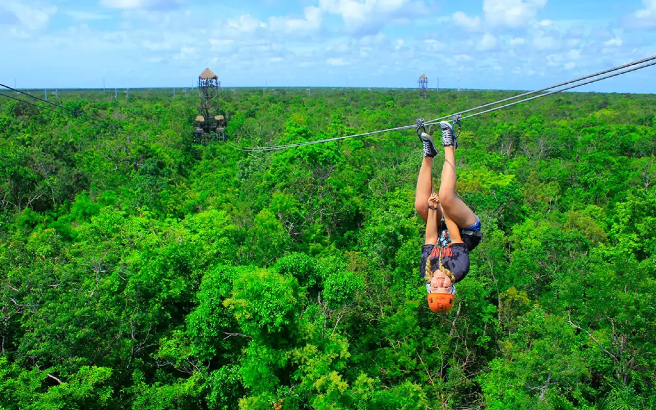 Upside down ziplining over a lush jungle canopy in Mexico