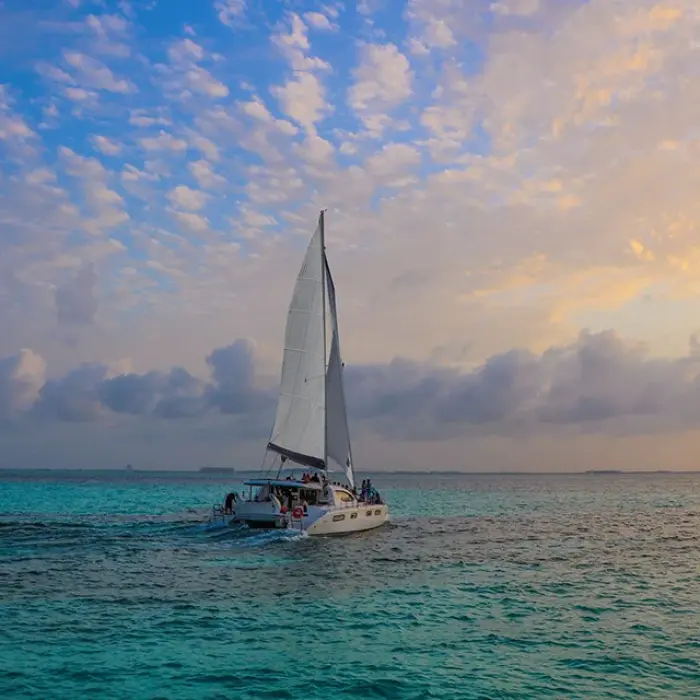 Sailboat on the ocean at sunset with a colorful sky in Playa del Carmen. Peaceful evening