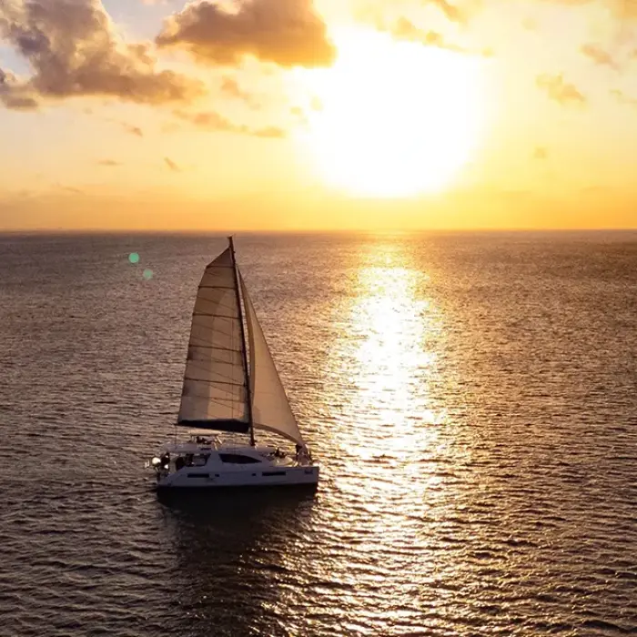 Sailboat silhouetted against a colorful sunset in Playa del Carmen. Evening sail