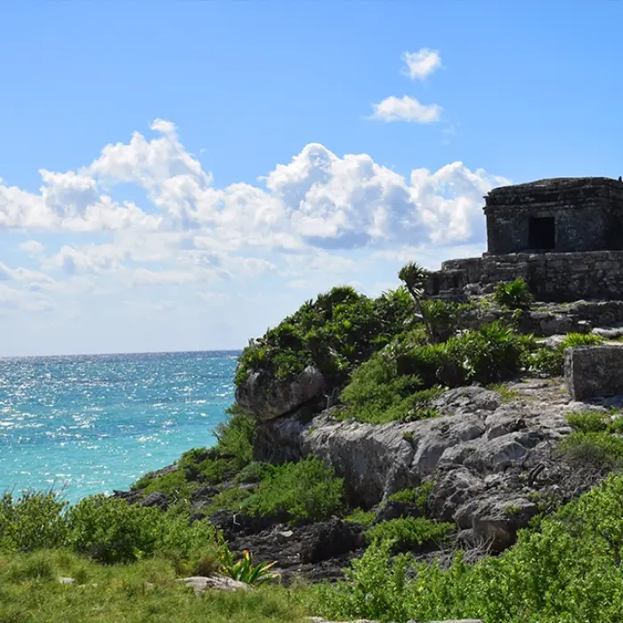 Ancient Mayan temple atop a cliff overlooking the ocean in Tulum