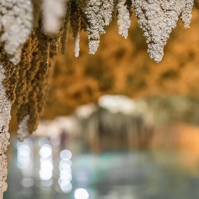 A beautiful underground cenote with rock formations and turquoise water