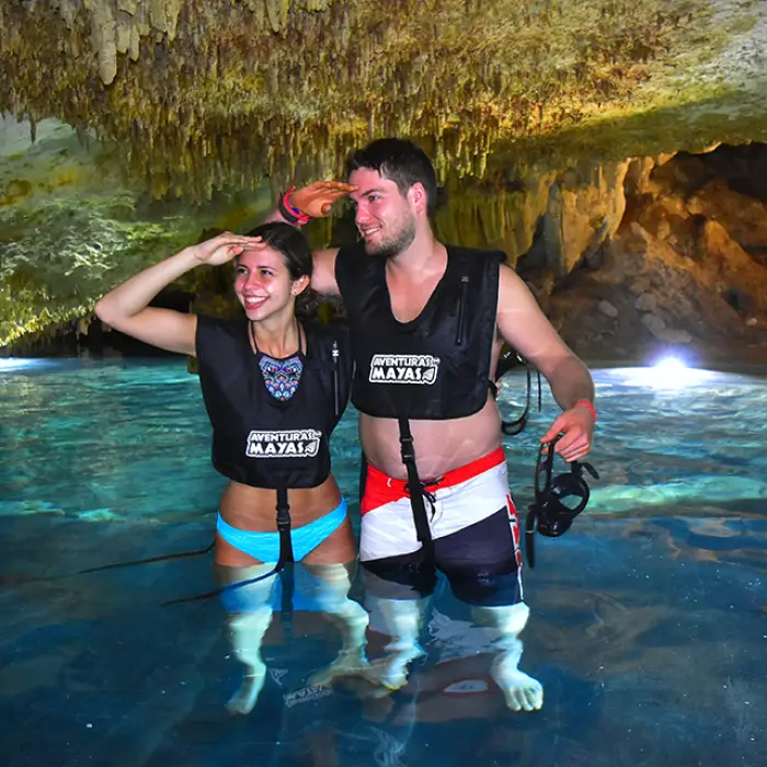 Happy couple cooling off inside a magical cenote, part of the Tulum snorkeling experience