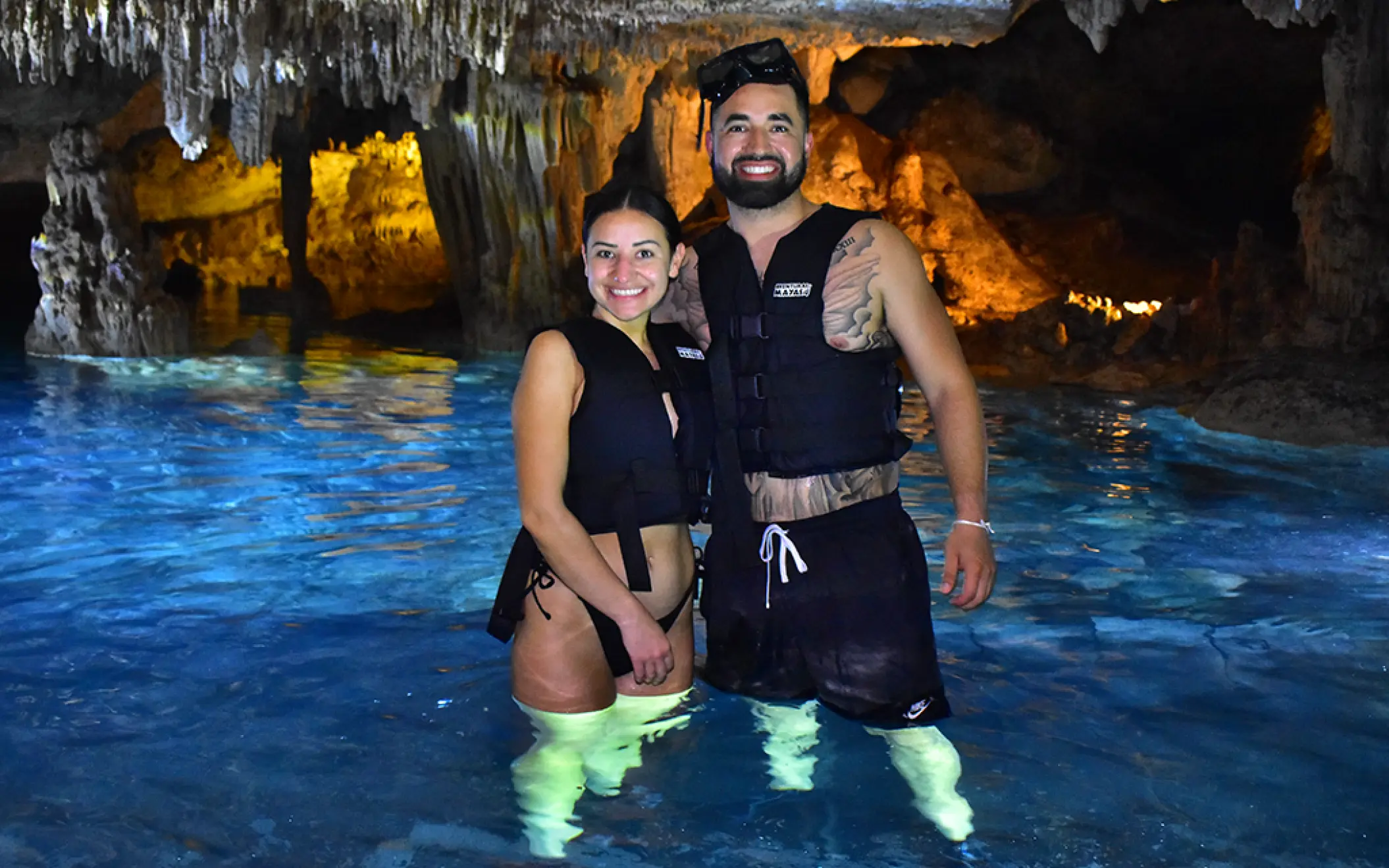 Couple smiling and enjoying a refreshing swim in a mystical cenote during their Tulum adventure