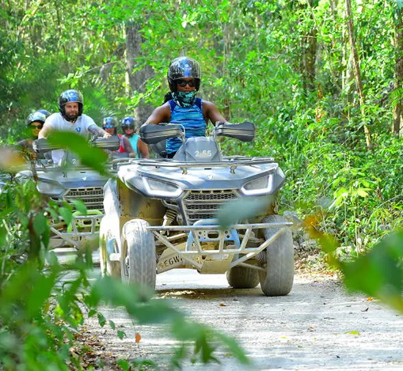 A group of friends driving ATVs through the lush jungle trails of Tulum
