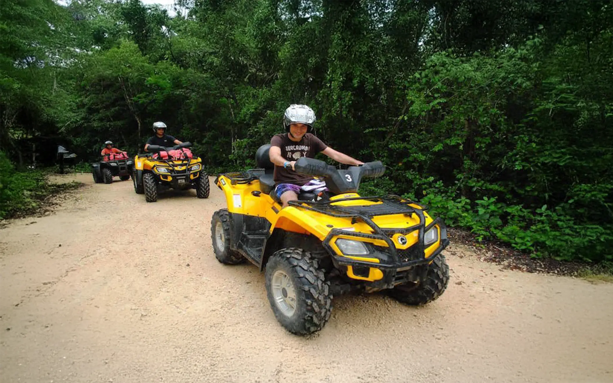 A group on an ATV tour enjoying a scenic jungle path during their Tulum experience
