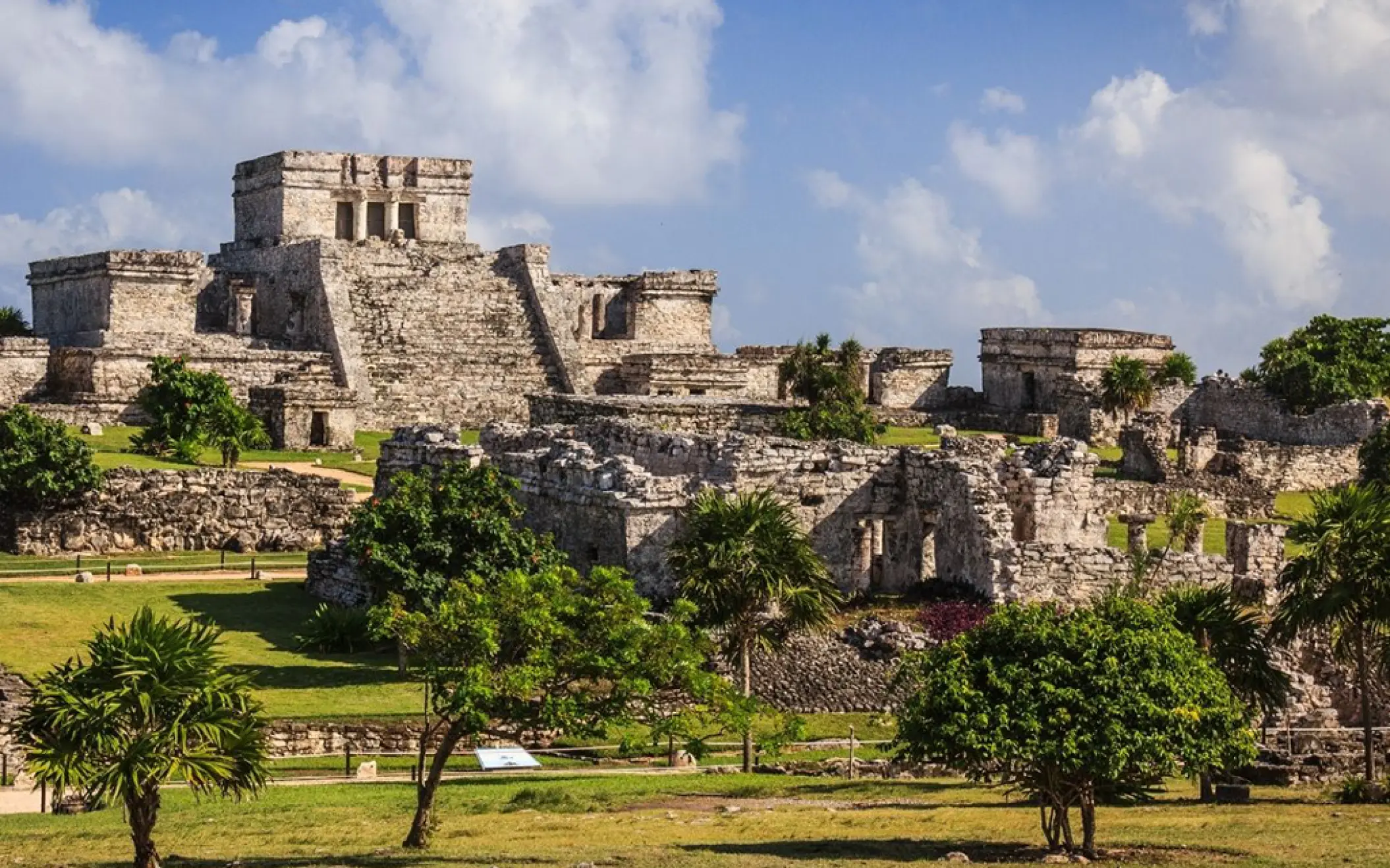 The iconic ruins of Tulum standing tall against a bright blue sky, full of ancient history