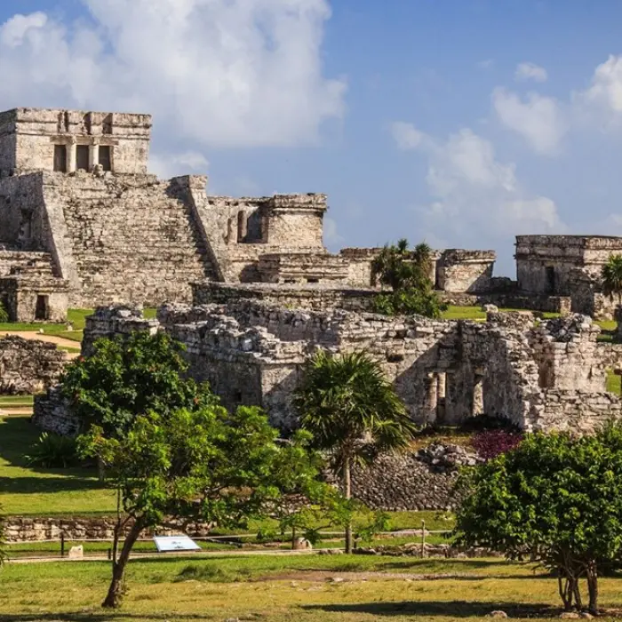 The iconic ruins of Tulum standing tall against a bright blue sky, full of ancient history