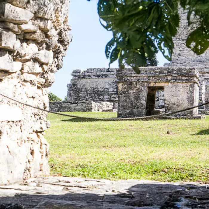 A unique view of the Tulum ruins through a stone wall, capturing the mystery of the Mayan era